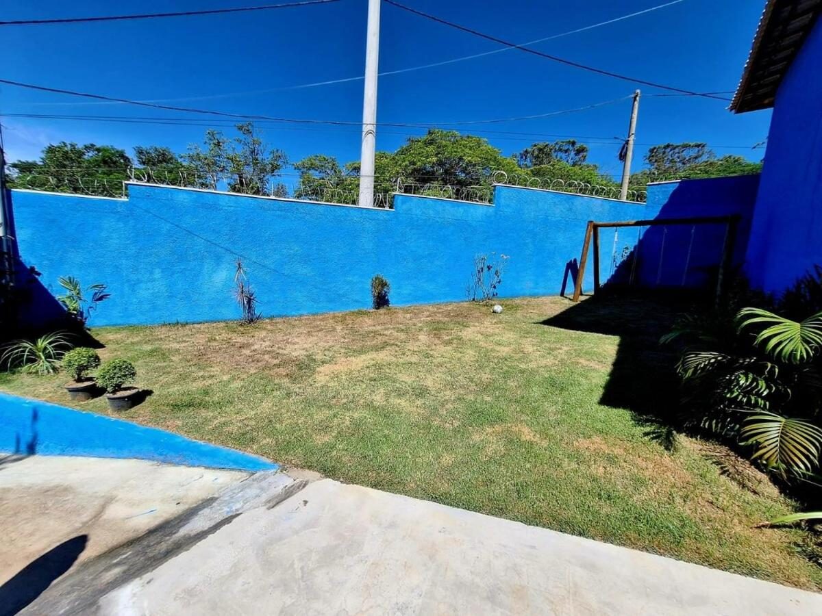 Jardim gramado com balanço de madeira e muro azul