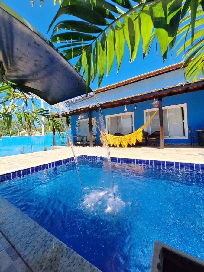 Piscina com coqueiros e área de descanso