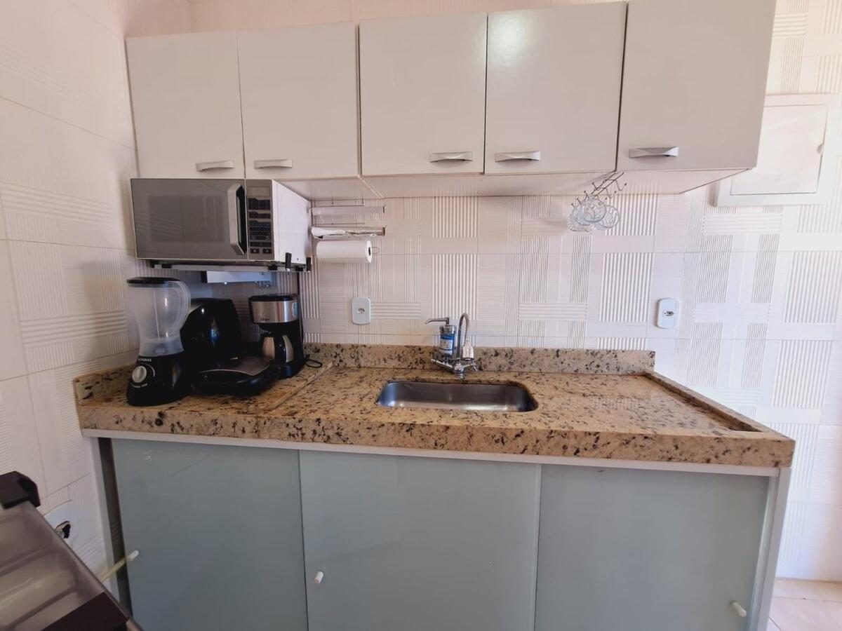 Cozinha com micro-ondas, cafeteira e pia